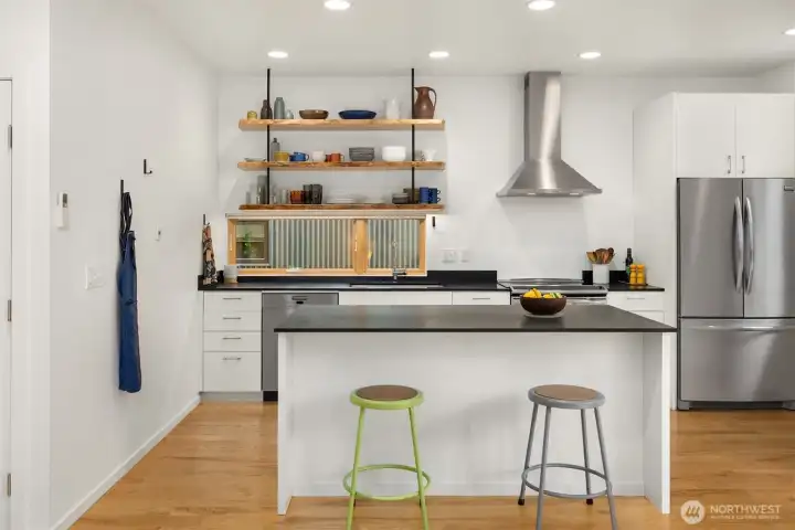 Custom live-edge open shelving by local woodworker Trevor Flake offers elegant and practical storage.