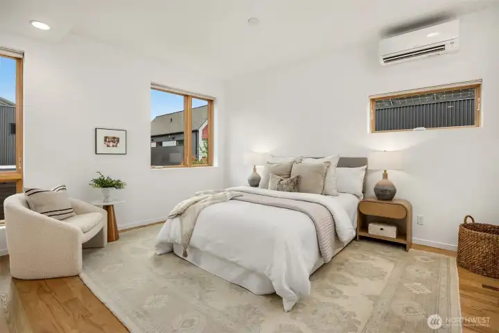 The spacious primary features ash hardwood floors, a newer mini-split head for AC and heat, and plenty of sky through the large east-facing windows.