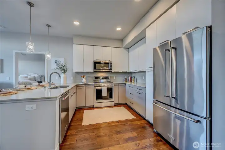 Beautiful Chef's kitchen with updated cabinetry, stainless appliances, slab quartz and wood flooring.