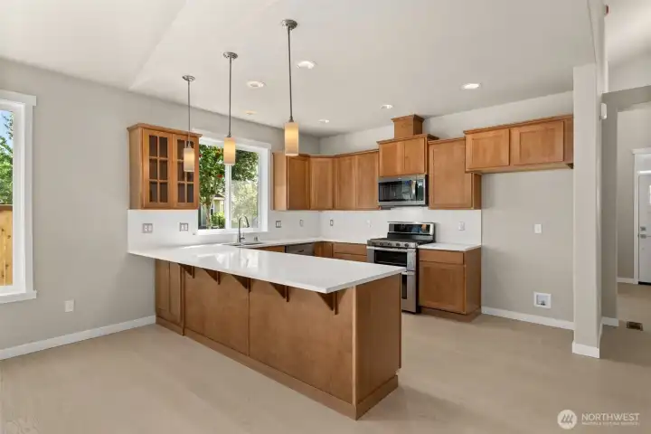 Kitchen features new Toffee-stained Maple Shaker-style cabinets with quartz countertops, full tile backsplash and extended eating bar.