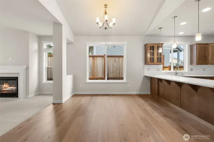 Bright and open dining area with beautiful hardwood flooring with chandelier including eating bar with pendant lights for additional entertaining space.