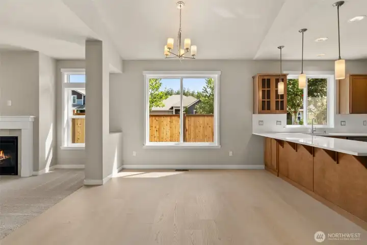 Bright and open dining area with beautiful hardwood flooring with chandelier including eating bar with pendant lights for additional entertaining space.