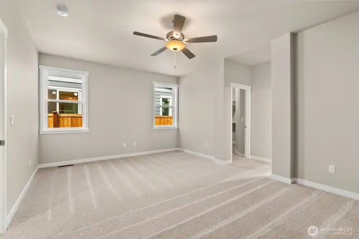 Inviting and spacious primary bedroom with ceiling fan for added comfort.