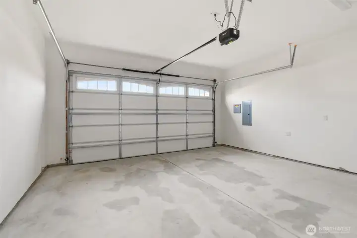 Two car garage with garage door opener and 2 remotes.