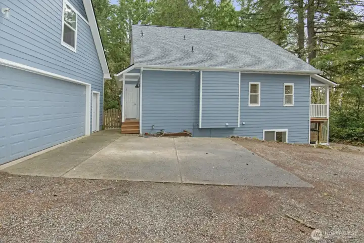 Side view of home with back door access and gate into the backyard and patio.