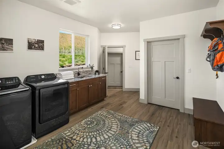 Awesome laundry room with large closet storage space, sink, washer and dryer stay! Door that is open leads to garage and studio above garage.