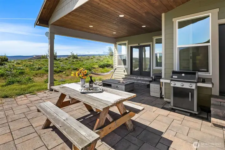 Two sets of French doors lead to covered back patio, one from primary bedroom and the other from living room