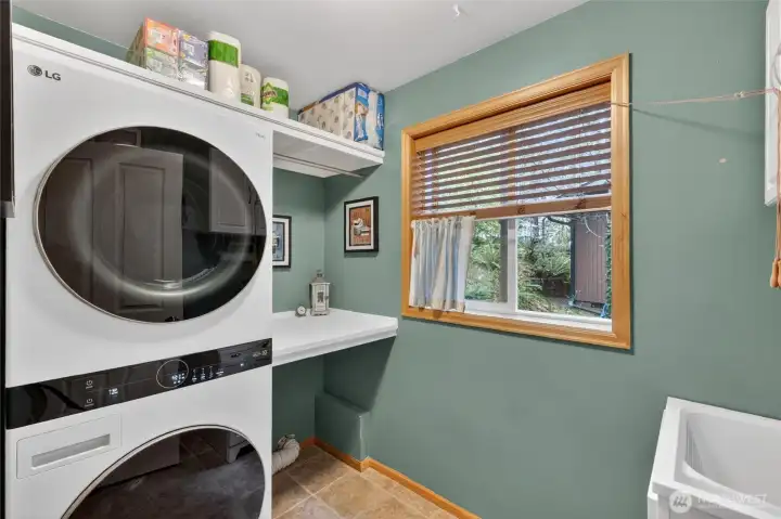 Main floor Laundry room with extra storage space and utility sink.