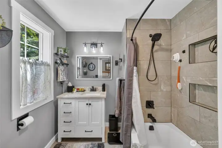 Primary bath has been recently updated with new vanity, tiled tub surround and tile flooring.