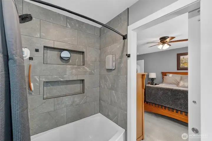 Beautiful tile surround with well thought out storage shelves.