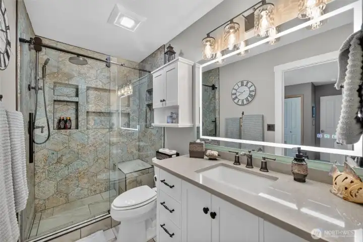 Recently remodeled Jack & Jill bath with beautifully tiled shower, new vanity, lighted mirror and tile flooring.