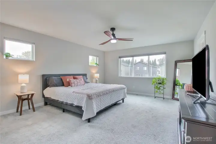 The oversized primary bedroom overlooks the beautiful backyard.