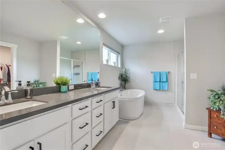 The spa-like primary bathroom features a dual vanity and deep soaking tub.