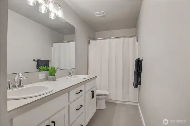 The upper-level full bathroom features a dual vanity.