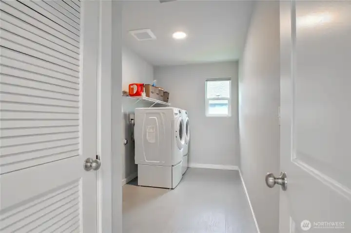 The upper-level laundry room features storage options, as well as, room for a folding table.