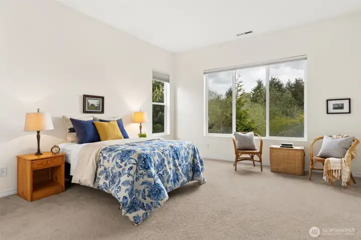 Generous primary bedroom with views out to greenbelt/wetland area