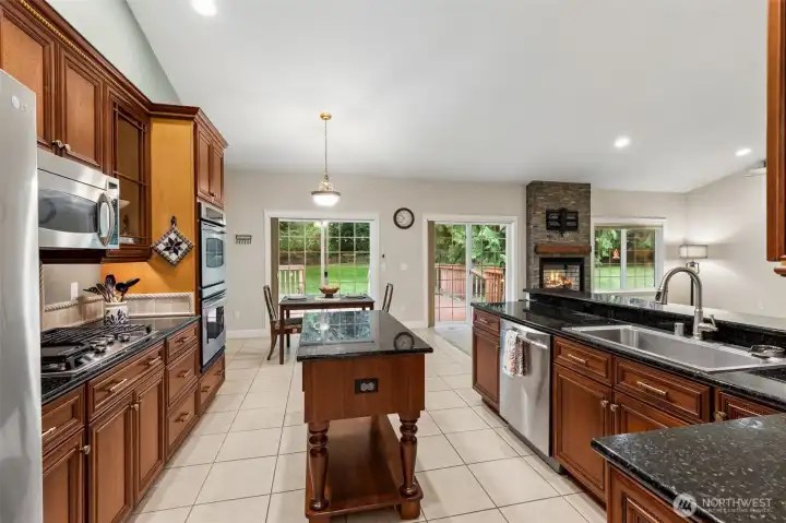 Chef-inspired kitchen with rich cherry cabinetry, granite countertops, stainless steel appliances, and an oversized walk-in pantry.