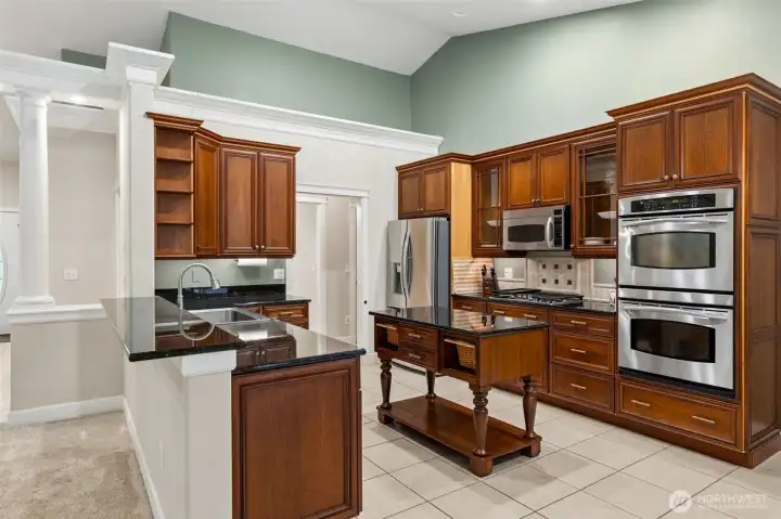 Chef-inspired kitchen with rich cherry cabinetry, granite countertops, stainless steel appliances, and an oversized walk-in pantry.