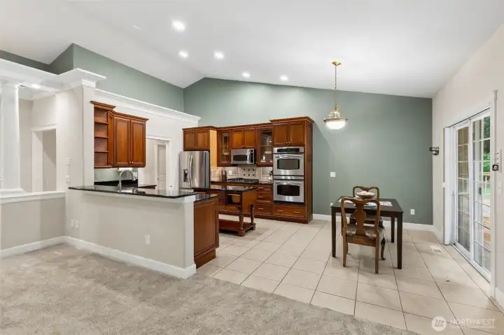 Chef-inspired kitchen with rich cherry cabinetry, granite countertops, stainless steel appliances, and an oversized walk-in pantry.