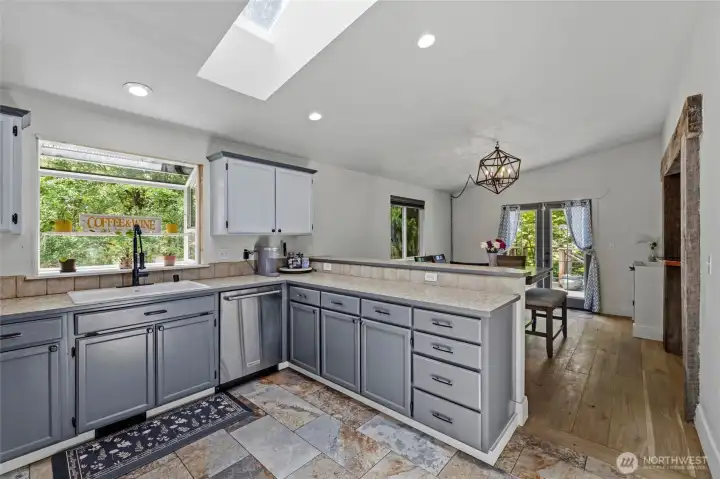 Love the garden window and skylight for lots of natural light. Stone floors in the kitchen and entry and engineered hardwood throughout.