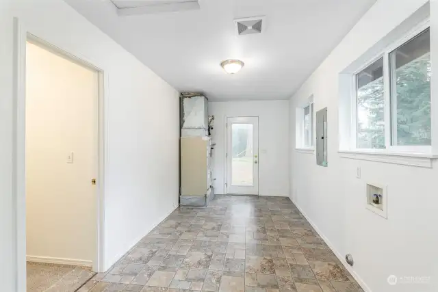 Utility/mud room with side entry door.