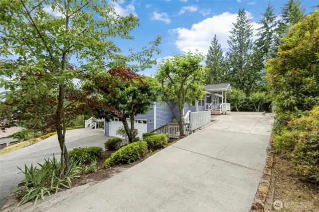 A long, private driveway winds up to the home’s charming covered entry. Mature landscaping and manicured shrubs line the way, offering beauty and privacy.