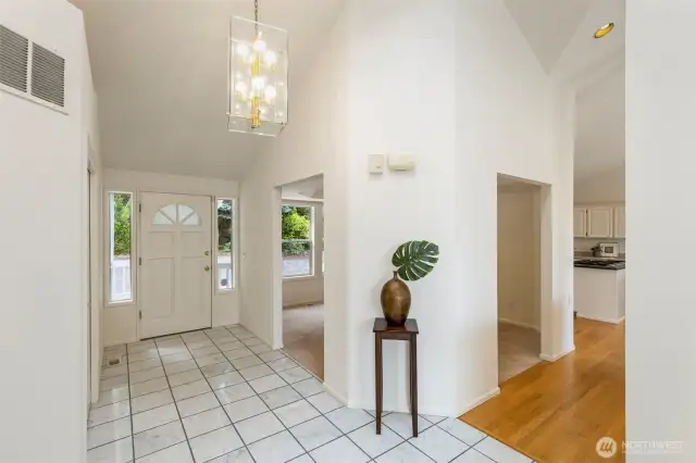 Bright and open, the entry hall boasts marble tile floors and a high ceiling. A graceful transition space that sets the tone for the rest of the home’s welcoming interior.
