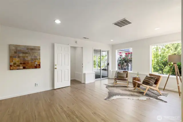 Another angle of the lower-level living space shows access to the carport & backyard through sliding doors, along with fresh finishes and flexible space for lounging or entertaining.