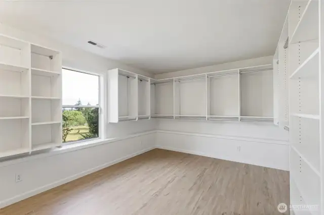 Another flexible bedroom with a window view and extensive built-in shelving perfect for storing seasonal wardrobes or creating a stylish dressing room.