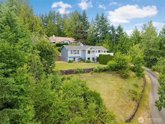 The home’s elevated position and sprawling lot with mature landscaping and terraced gardens give the property a well-established feel.
