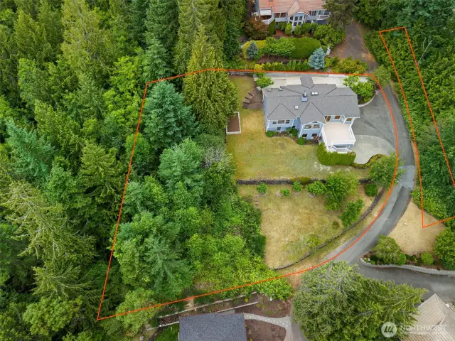 Property lines are outlined in this aerial image, giving a clear view of the lot size and layout. Surrounded by trees and located on a quiet street, this home is a true retreat.