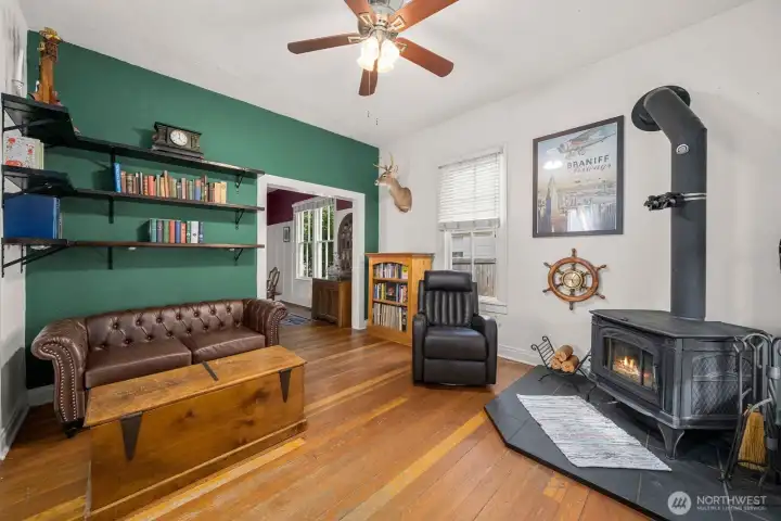 Enter directly into primary living space - complete with newer wood burning stove and built-in bookcases.  New paint, original wood floors, and ceiling fans.
