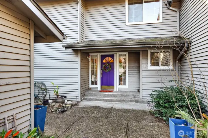 Inviting covered entry with charming door, sidelights & retractable screen door. Clean lines, neutral siding & cozy approach create warm curb appeal.