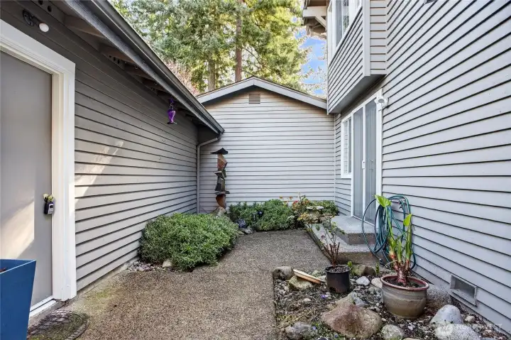 Private patio space with low-maintenance landscaping, decorative fountain & cozy seating area. Quiet setting ideal for relaxing or outdoor enjoyment.