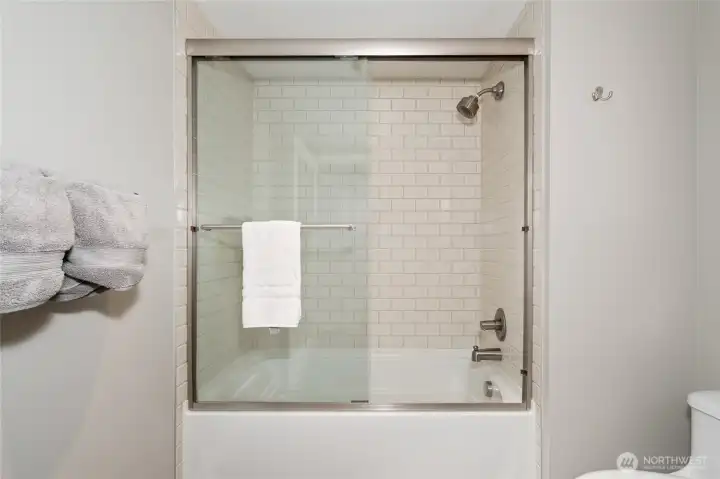 Bathtub and shower with stylish glass sliding doors. Bathtub and shower with stylish glass sliding doors.