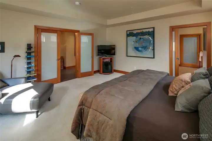 Looking across the spacious primary bedroom with the primary bath to the right and the very large walk-in closet beyond.