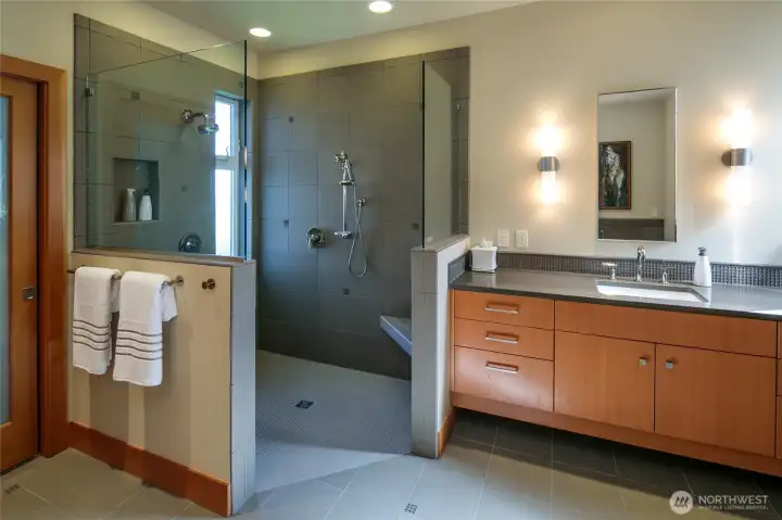 This bath has two separate floating vanities and a doorless zero clearance shower with a heater below the bench and radiant heated floors in the entire bathroom.