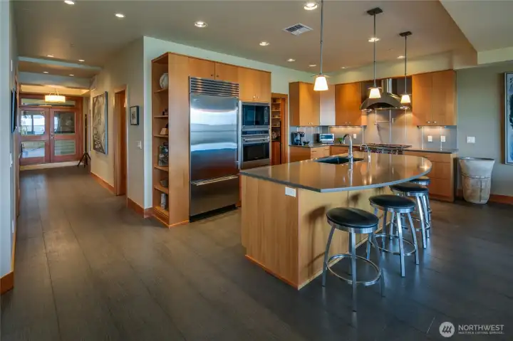 Looking at the kitchen and the entry hallway with the very large island that has an eating bar for 4.