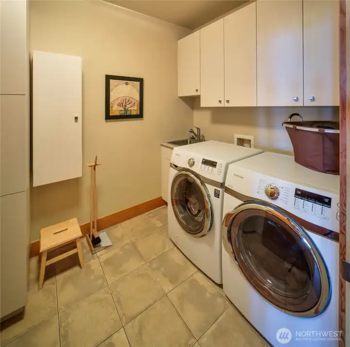 The laundry room has a built-in ironing board as well as a deep stainless sink.