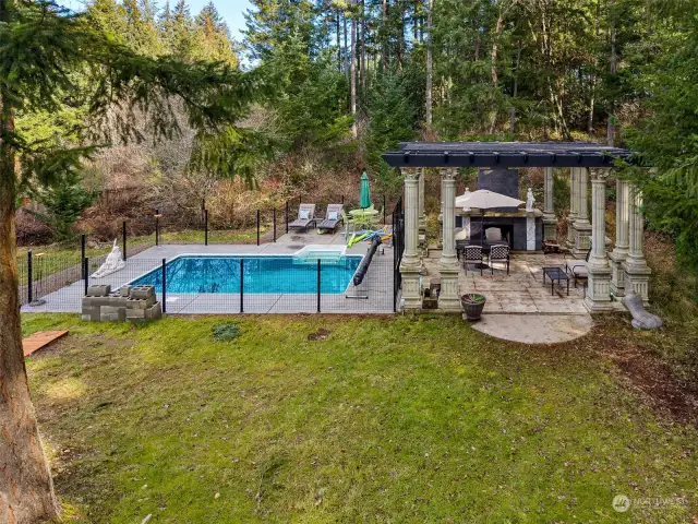 Both of the pools come with covers, and ensure that you will have water-fun options no matter the season. A perfect setting for gathering friends and family, where every day feels like a special occasion! A poured concrete patio with gorgeous pillars holding up the pergola, plus handsome wood burning fireplace at the end creates a fantastic outdoor living space, plus all of the outdoor furniture is included!