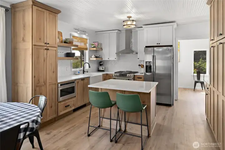 Kitchen island with cute eating bar. Don't miss the toe kick drawer under the built-in microwave!