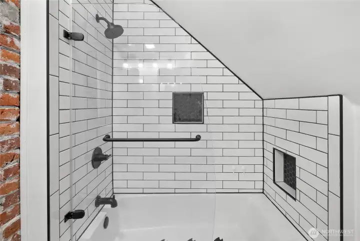 Exposed historic brick & new tiled tub/shower surround.