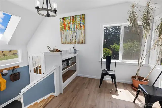 Sitting area by main floor stairs to back entry & basement. This could be storage, reading nook, breakfast nook, home office?