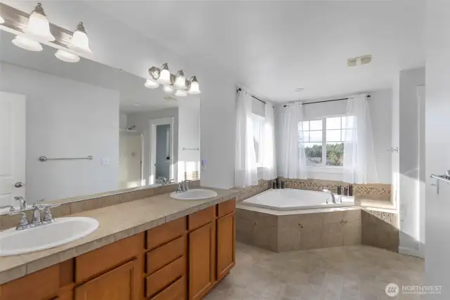 Primary suite is very spacious with double sinks, double corner window and separate shower.  A walk in closet that fits plenty.