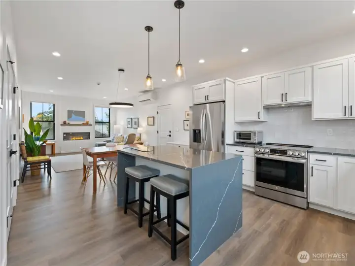 LVP flooring throughout the main floor with open kitchen, living and dining spaces.