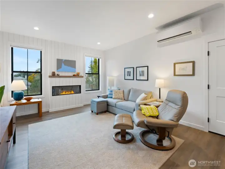 living space with electric fireplace and shiplap detailing.