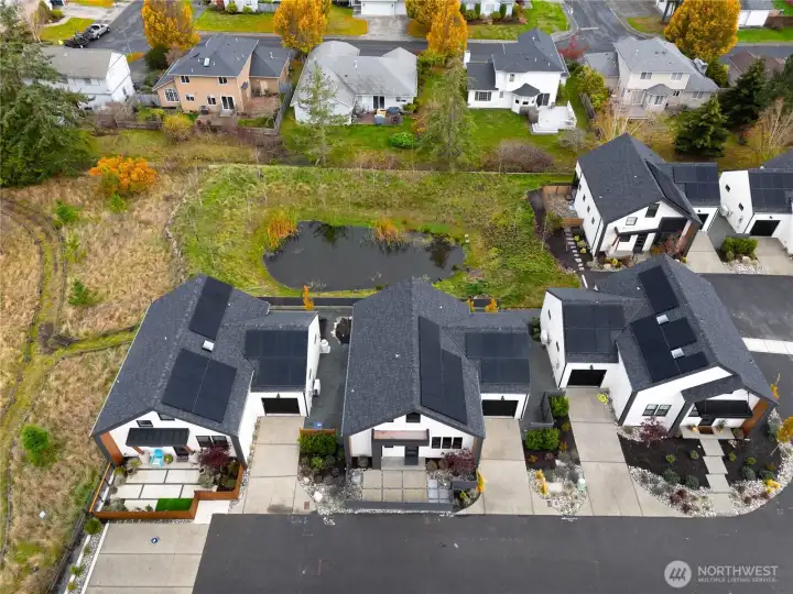 View showing the cottages backing up to the pond, walking trails to the side around an additional pond.