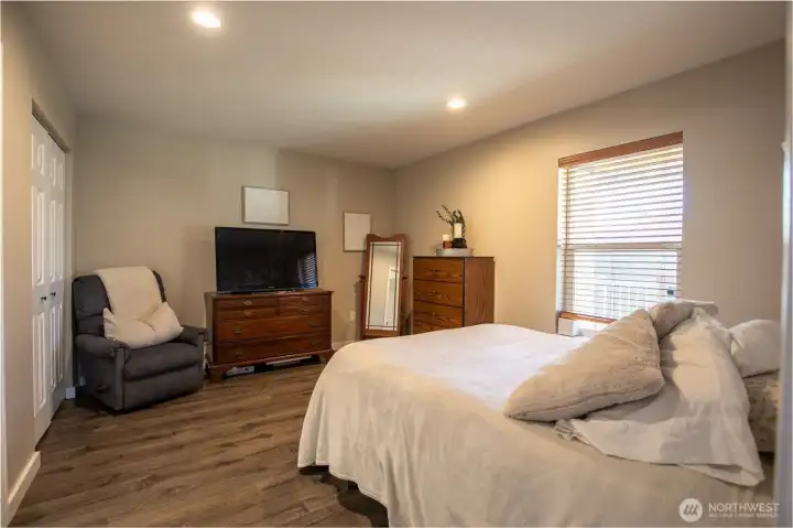 Spacious bedroom with abundant natural light and wood flooring.