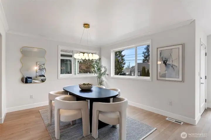 The dining room features new luxury vinyl plank flooring, a stunning chandelier and windows on 2 sides for maximum natural light.