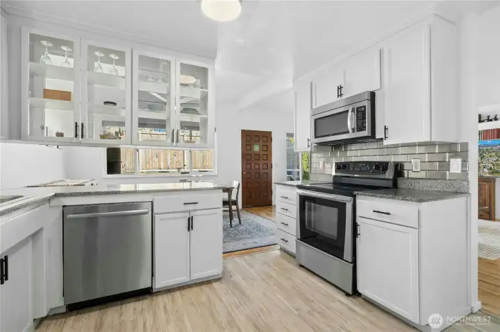 Kitchen with LVP flooring and stainless steel appliances.